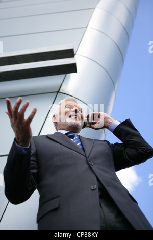 Senior businessman taking a call outdoors Stock Photo