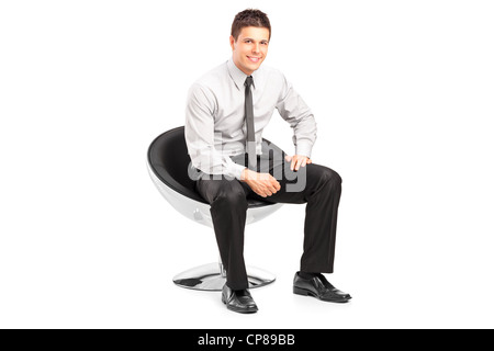 A young handsome male sitting on chair and posing isolated on white background Stock Photo