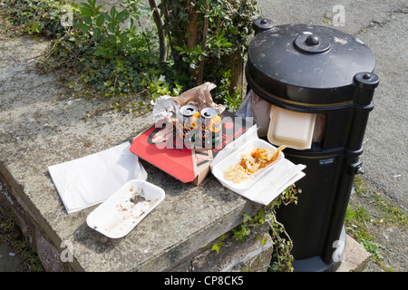 Fast Food waste and litter next to a full litter bin Stock Photo