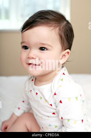 Happy baby sat on bed Stock Photo