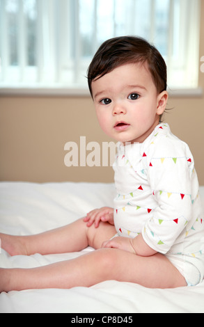 Adorable baby sat on bed Stock Photo