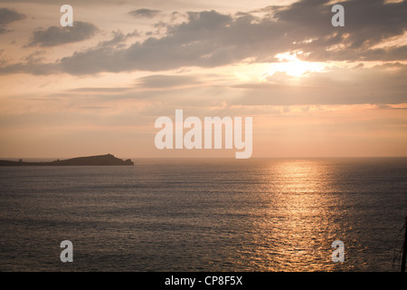 sunset over sea off Newquay Cornwall dramatic clouds sparkling orange light Stock Photo