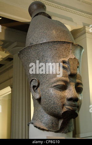 Head from monumental red granite statue of an egyptian king wearing the double crown. Probably Amenhotep III. Around 1390 BC. Stock Photo