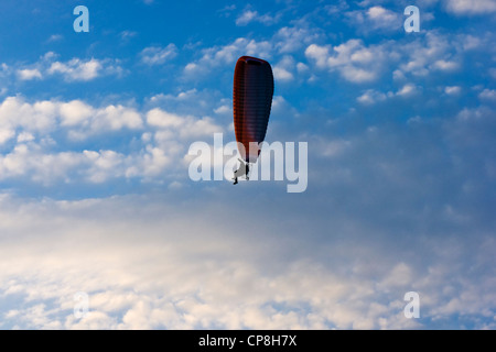 Clear blue sky with white clouds and lone paraglider. Stock Photo