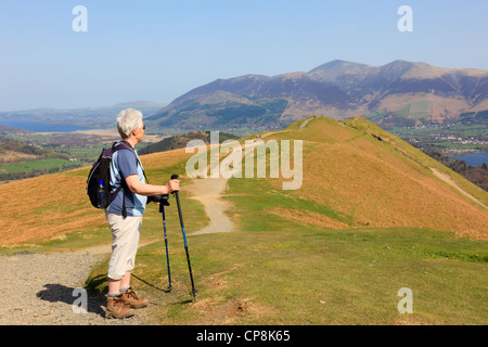 Active senior woman hill walking with trekking poles on a footpath to Catbells in Lake District National Park near Keswick Cumbira England UK Stock Photo
