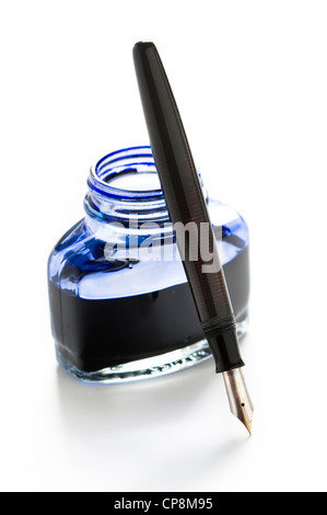 a fountain pen leaning on a bottle of blue ink isolated on a white background Stock Photo