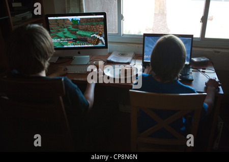 Two boys playing Mine craft video game at home. Stock Photo