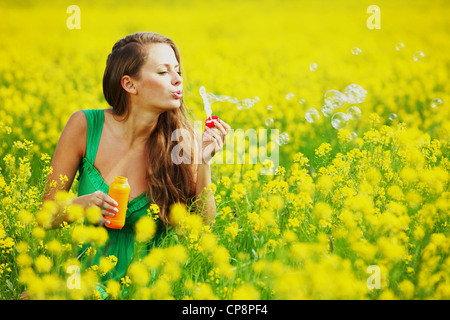 woman start soap bubbles on yellow flower field Stock Photo - Alamy