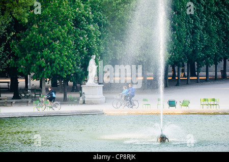 Family riding rental bicycles in the early morning, Jardin des Tuileries, Paris, France Stock Photo