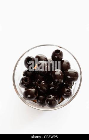 Black olives in a glass bowl isolated on white background with ...