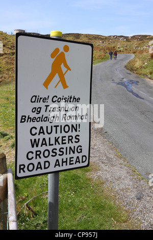 Sign warning motorists of walkers on a winding road ahead. Stock Photo