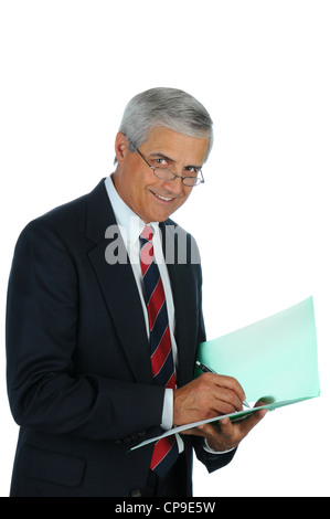 Portrait of a smiling middle aged business man writing in a file folder. Vertical format isolated on white. Stock Photo