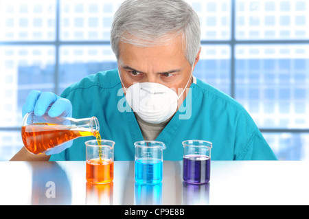 Scientist in modern laboratory pouring and measuring liquids in assorted beakers. Horizontal format. Stock Photo