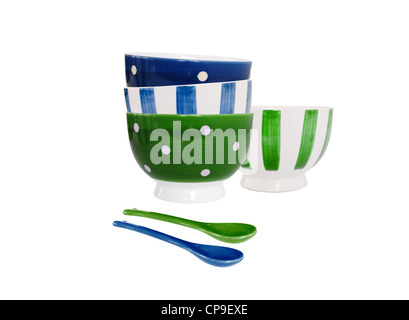 Bowls in blue and green and different patterns and two spoons on white background Stock Photo