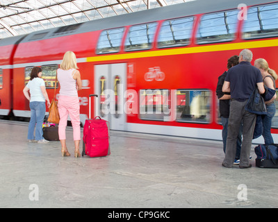 The German Railway in Berlin - Spandau.  A mainline train arriving with passengers on the platform interior of a station Stock Photo