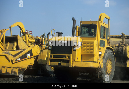 Two Caterpillars-631G articulated landscraper vehicles transversing upon a land redevelopment site. Stock Photo