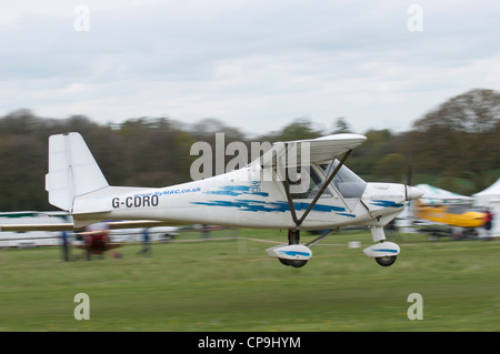 Ikarus C42 MIcrolight aircraft takes off from Popham airfield during the May Fly-In. Stock Photo