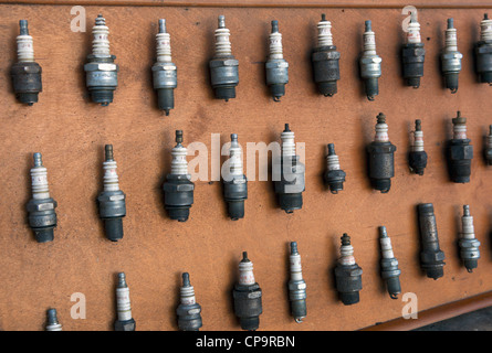 Collection of old spark plugs displayed on a board Stock Photo