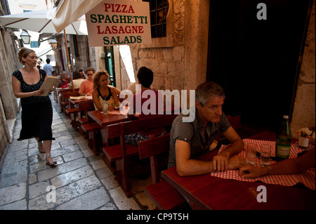 Outdoor dining in a Italian restaurant in a narrow street, Old Town, Dubrovnik. Croatia. Stock Photo