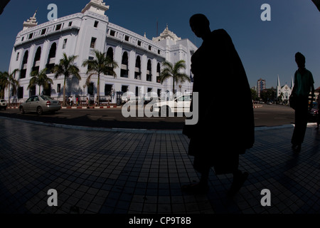 Silhouette of a monk in front of the Strand Hotel downtown Yangon Burma Myanmar Stock Photo