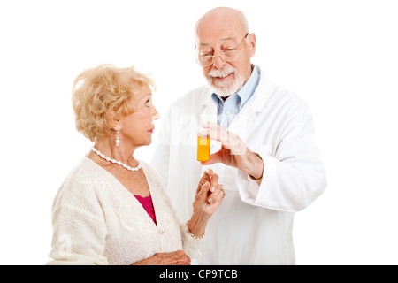 Pharmacist giving dosage instructions to an attractive senior patient. Isolated on white. Stock Photo