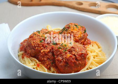 Meatballs in red sauce over linguine in white bowl Stock Photo