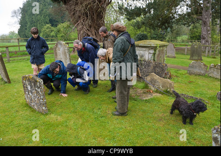 Visiting interesting local church graveyard part of a guided walk around cider apple orchards during THE BIG APPLE BLOSSOMTIME festival at the village of Putley near Hereford Herefordshire England UK Stock Photo