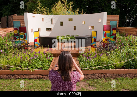 Woman takes photo of sound wall in beautiful, interactive music therapy garden 'A Sound Garden' - RHS Flower Show, Tatton Park, Cheshire, England, UK. Stock Photo