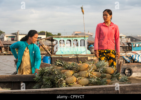 Woman selling pineapples from a boat in the floating market, Cai Rang near Can Tho, Mekong River Delta, Vietnam Stock Photo