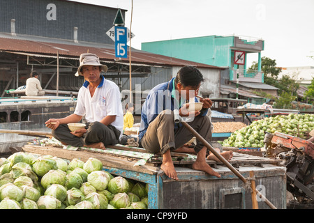 Men selling vegetables from a boat in the floating market, Cai Rang near Can Tho, Mekong River Delta, Vietnam Stock Photo