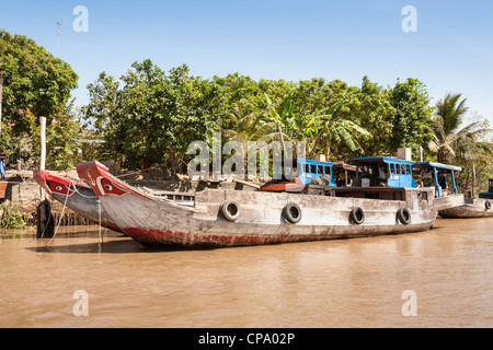 Typical cargo boats moored on the river, between Cai Be and Vinh Long, Mekong River Delta, Vietnam Stock Photo