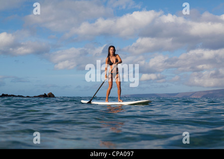 Fit, athletic woman stand up paddles at Palauea Beach near Wailea, Maui, Hawaii. Stock Photo