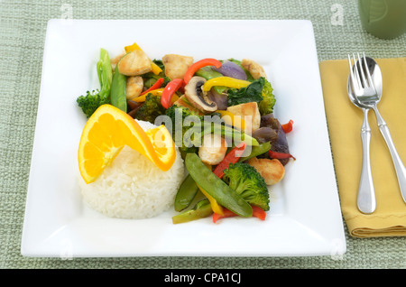 Chicken stir fry with rice on square white plate Stock Photo