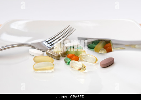 Dinner of a selection of vitamins (omega 3, Co-enzyme Q10, peppermint, chondroitin, ginkgo and ginseng) on white background Stock Photo