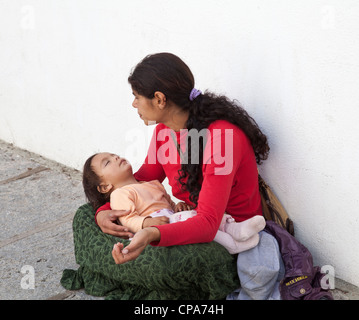 Young Roma Gypsy mother with child begging for money at an outdoor ...