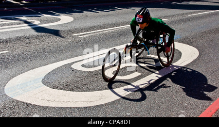 Male wheelchair athlete competitor crossing a 20 MPH sign during the 2012 London marathon England Europe Stock Photo