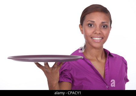 Attractive young waitress holding an empty tray Stock Photo