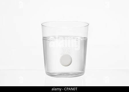transparent glass of water with an effervescent pills inside on white background Stock Photo