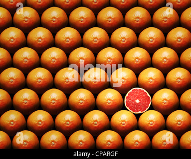 Grapefruit slice amongst many whole grapefruits Stock Photo