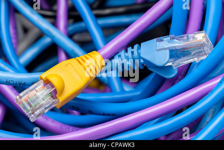 Macro shot of plugs on cat5e cables of many colors on top of tangle of wires Stock Photo