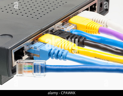 Macro shot of plugs on cat5e cables of many colors isolated against white background plugged into router Stock Photo