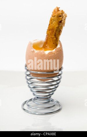 Soft boiled egg and soldiers toast in metal egg cup on white background Stock Photo