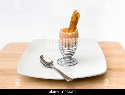 Soft boiled egg and soldiers toast in metal egg cup on white background Stock Photo