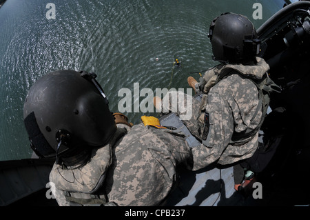 Sgt. 1st Class Robin McDaniel (left) and Sgt. Charles sit ready in a North Carolina Army National Guard UH-60 Black Hawk helicopter before raising a rescuer and victim during a North Carolina Helo Aquatic and Rescue Team training event at Lake Norman, May 8. The NCNGâ€™s C Company, 1-131st Aviation provided their aircraft and worked together with the Denver, N.C., Fire Department and NCHART in order to prepare for swift water/flood rescues that may happen in the future. Stock Photo