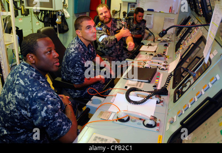 Sailors assigned to the U.S. 7th Fleet flagship USS Blue Ridge (LCC 19) listen as Marine Technician Leading Seaman Grant Darling explains the functions of the machinery control room aboard the Royal Australian Navy frigate HMAS Ballarat (FF 155). Blue Ridge conducted an exchange exercise between ships to demonstrate commitment to regional partnerships and fostering relations. Stock Photo