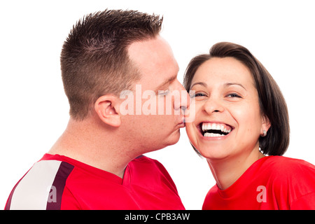 Portrait of young happy couple kissing and laughing, isolated on white background. Stock Photo