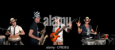 Portrait of four musicians playing isolated against black background Stock Photo
