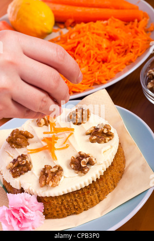 Close up of decorating carrot cake with fresh carrots. Stock Photo