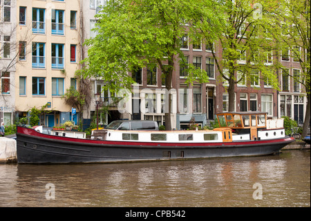 AMSTERDAM, NETHERLANDS - MAY 08, 2012:  Houseboat moored on Canal in Amsterdam Stock Photo