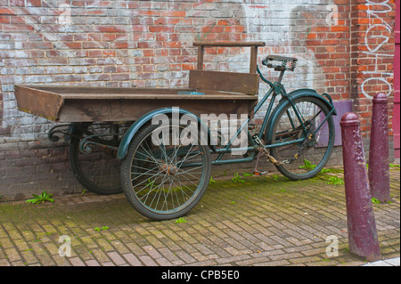 AMSTERDAM, NETHERLANDS - MAY 08, 2012:  Old delivery tricycle parked in Street Stock Photo